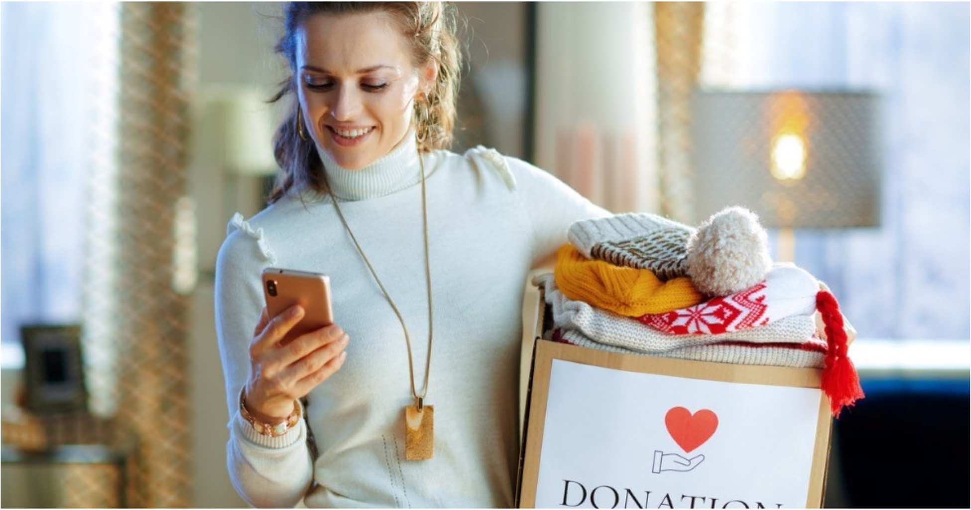 A woman prepares a box of clothes for donation.