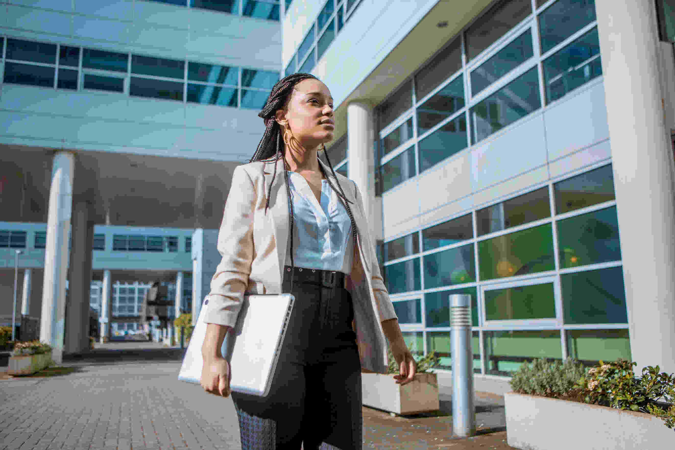 A women in business with her laptop in hand.