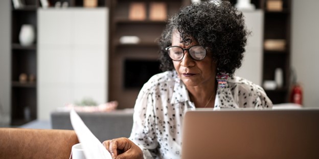 A woman looks at her retirement files with concern