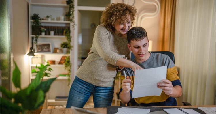 Mother points something out to son on piece of paper.