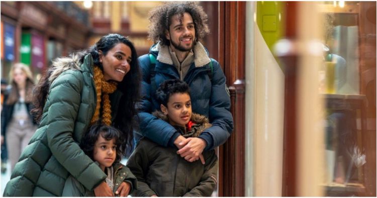 A man, women and two children window shopping