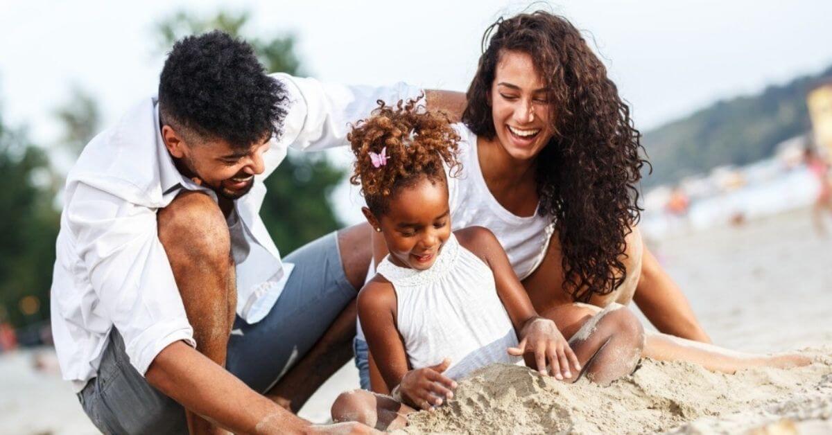 A young family play in the sand at the beach