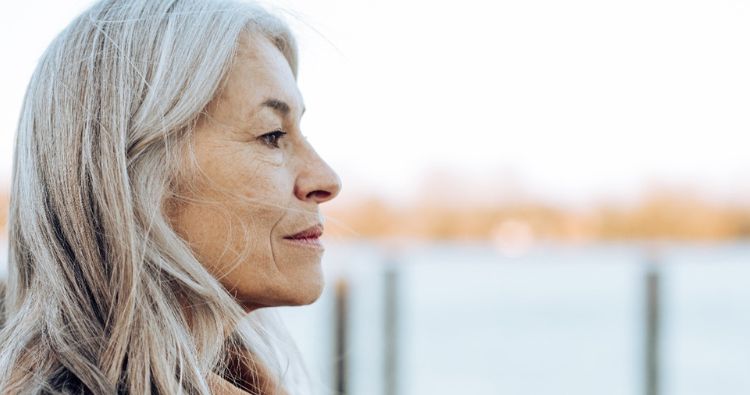 A woman looks out over a body of water.