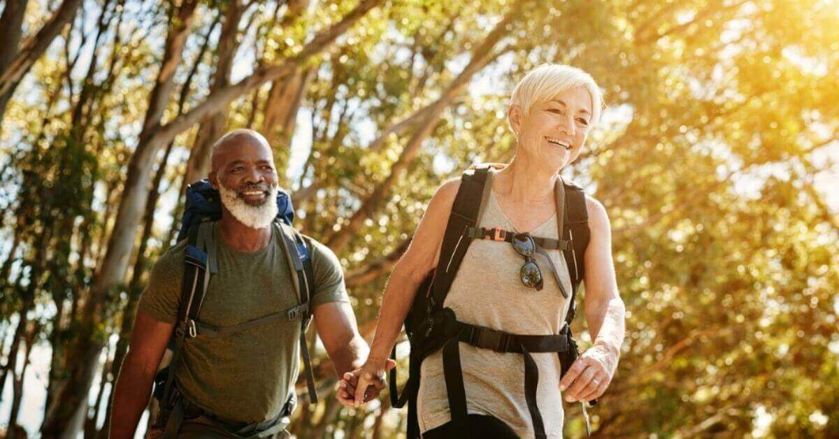 A senior man and wife hike together