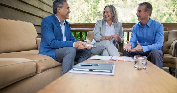 A couple sit outside to discuss their estate plan with a financial professional.