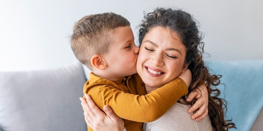 Young Hispanic mother received a kiss on the cheek from son