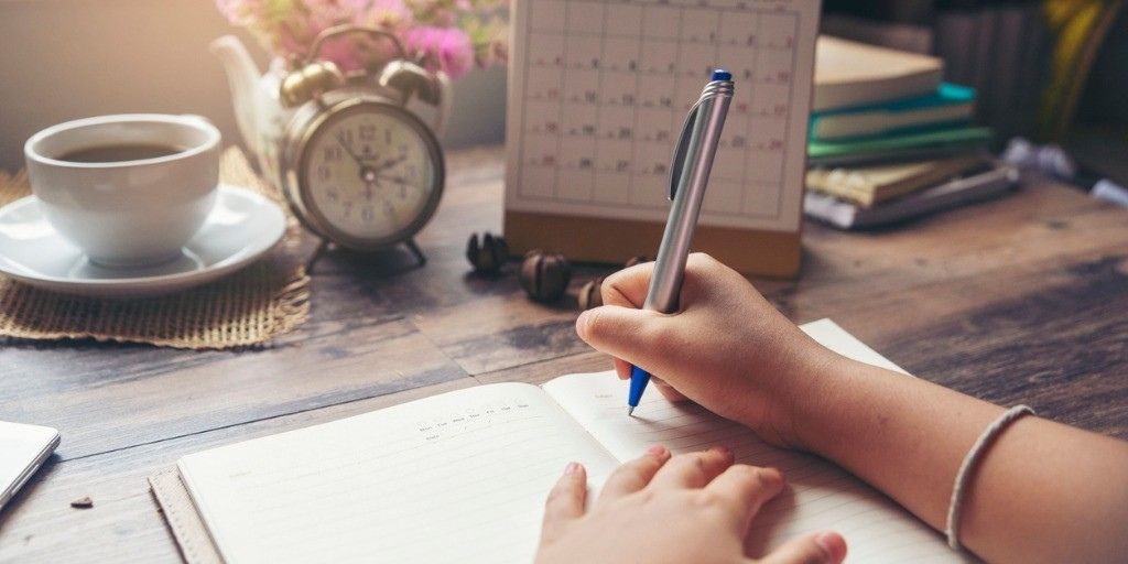 A handwriting in a notepad in front of a calendar