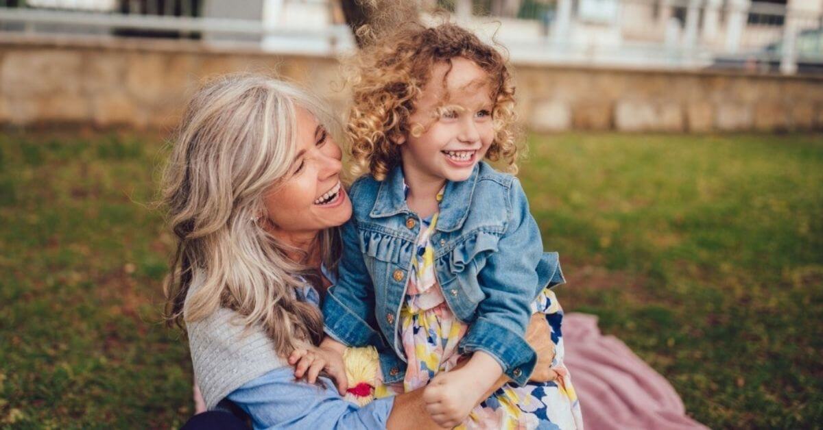 A grandmother embraces her young granddaughter