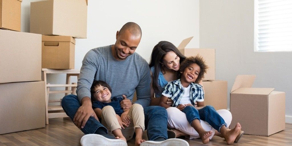 A young mixed-race family unpack boxes in their new home