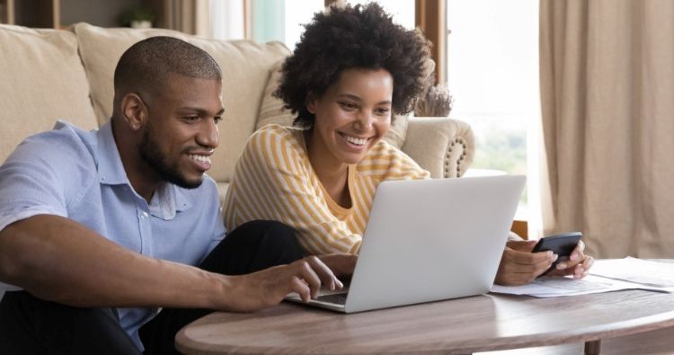 A millennial couple look at their financial information on a computer.