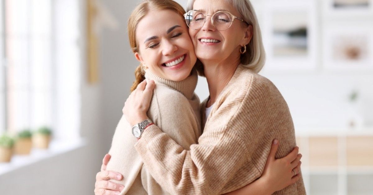 A woman tightly hugs her mom.