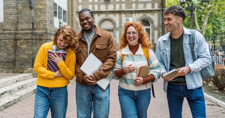 A group of college student smile while sitting in a lecture.