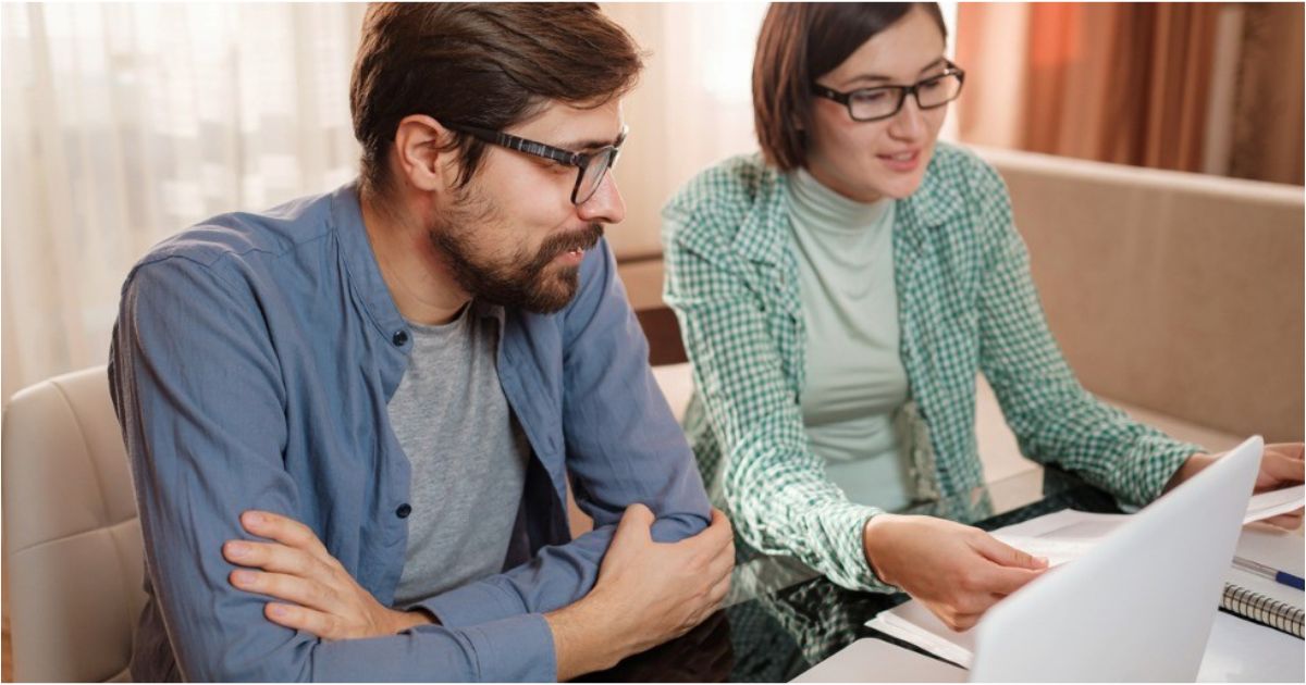 A pair of hands working on a computer to create a monthly budget.