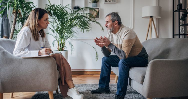 A man sits in a therapy session with his counselor