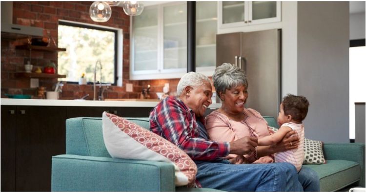 An older white couple stand in nature.