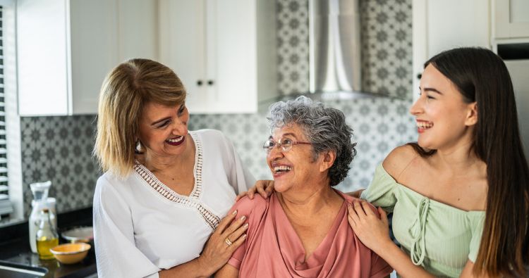 A group of women from the same family smile at each other.