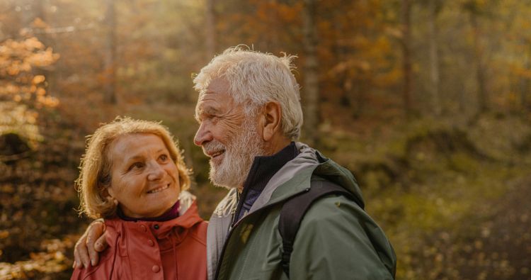 A wife turns and smiles at her husband while on a hike.