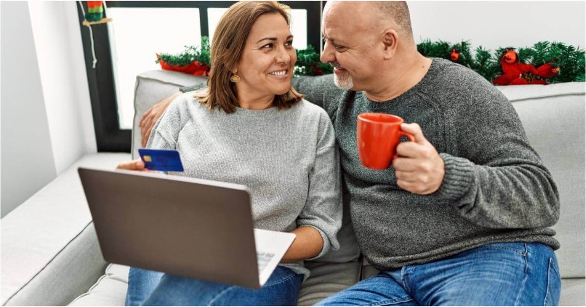 A couple sit discussing their finances over coffee