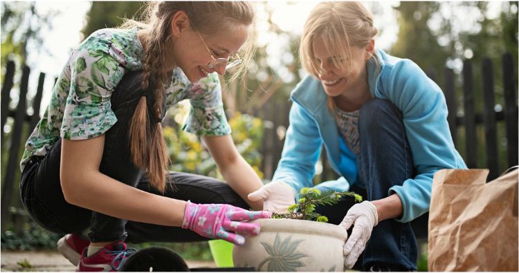 A mother and daughter garden together outside.