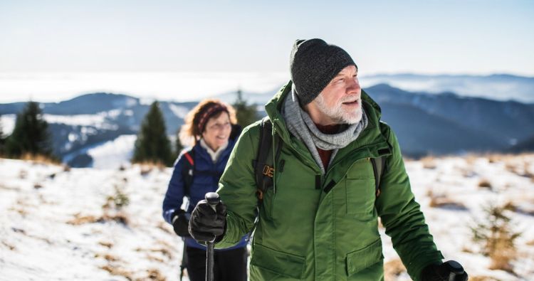 A retired coupld hike a snowy mountain together