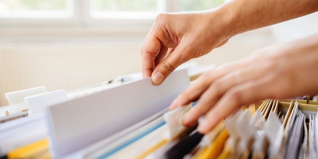 hands shuffle file papers in cabinet