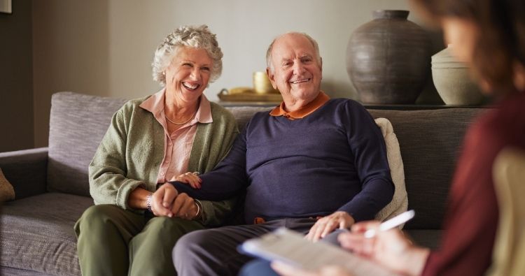 A retired agent couple sit in a meeting with a professional.