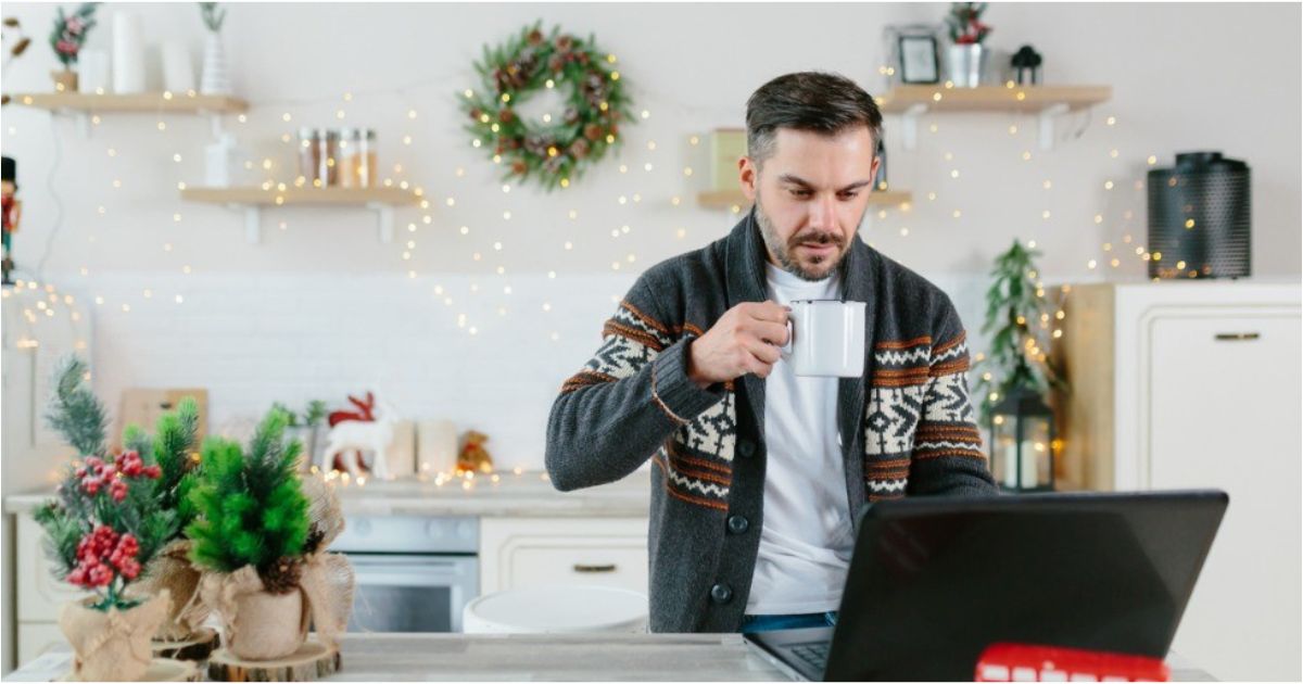 A man looks at his financial information while in his kitchen around Christmas-time.