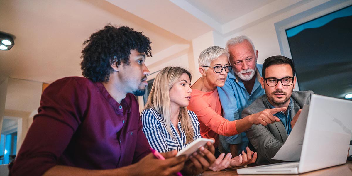 Five people looking at a laptop