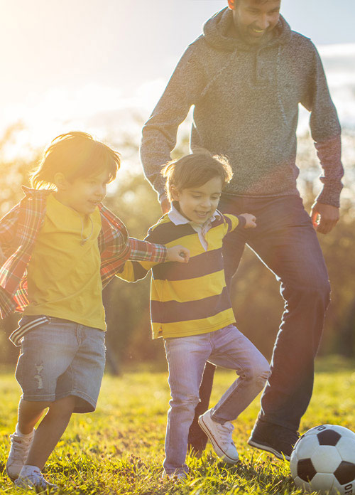 Parent with children playing soccer