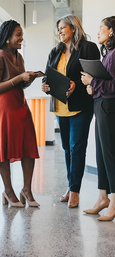 Three ladies standing around talking