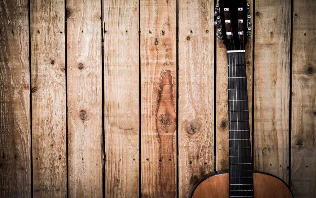 Guitar leaning against wooden boards