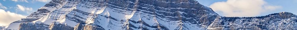 An image of jagged, snow-covered mountains and blue sky.